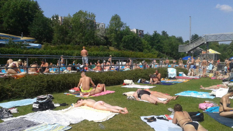 Lidé se sluní v areálu koupaliště Petynka